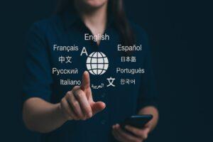 Global language translation concept with a woman touching a digital interface displaying various languages around a world icon.